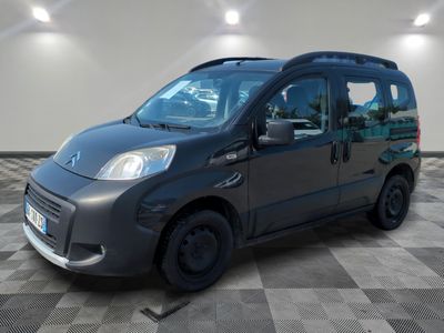 une camionnette grise garée sur un sol carrelé à damier dans un garage