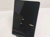 the back of a black tablet computer sitting on top of a white table