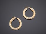 a pair of gold hoop earrings on a black background