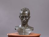 bronze bust of a man on a wooden pedestal
