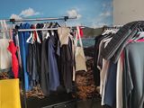 a rack of clothes in front of a window with a view of the ocean