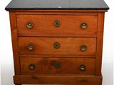 a small wooden chest of drawers with a marble top