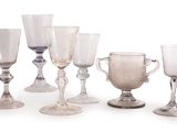 six verres à vin posés les uns à côté des autres sur une surface blanche