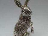 une image représentant une figurine de lapin en argent assise sur ses pattes arrière