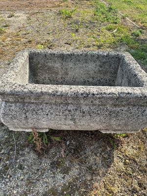 an old stone sink sitting in the middle of a field