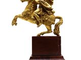statue of a man riding a horse on a wooden base
