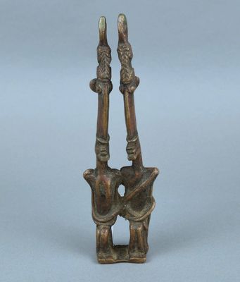 deux figurines en bronze représentant deux personnes se tenant par la main, l'une tenant l'autre dans ses bras