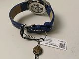 a wrist watch with a key and a tag on it