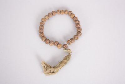 un gros plan sur un bracelet en perles de bois orné d'un pompon