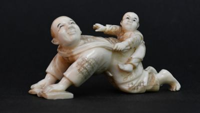 une figurine représentant un homme et un enfant allongés par terre