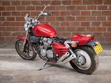 a red motorcycle that is parked in front of a brick wall