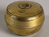 a small gold box sitting on a white surface