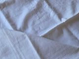 a close up of a pair of white linens on a bed