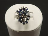 a close up of a ring with blue and white stones on it