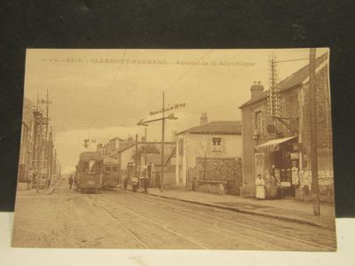 une vieille photo représentant une scène de rue avec un train qui arrive sur les rails