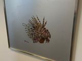 une image représentant un poisson accrochée au mur à côté d'un miroir