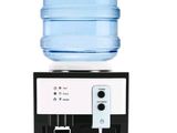 a water dispenser with a glass of water on top of it