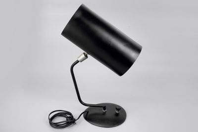 a black table lamp on a white background with a cord