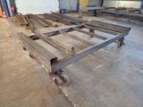 de nombreuses pièces de bois posées sur des roues dans un entrepôt