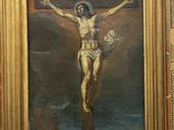 un vieux tableau représentant Jésus sur la croix, dans un cadre doré
