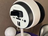 a white and black clock on a table with a golf ball