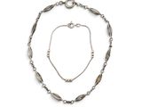 un gros plan d'un collier et d'un bracelet sur fond blanc