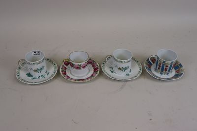 four cups and saucers are lined up on a table