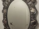 miroir ovale argenté orné de feuilles tout autour du bord