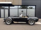 an image of a black sports car parked in front of a building