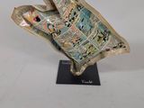 sculpture of a bird made out of newspaper on a black stand