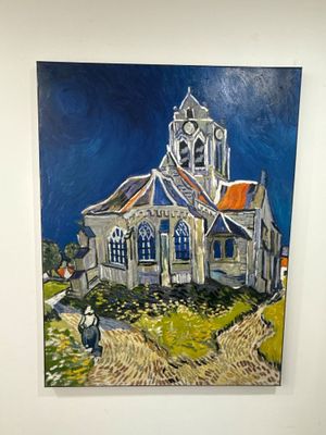 une peinture représentant une église accrochée au mur d'une pièce