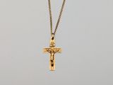 a gold cross pendant with a black stone on a gold chain