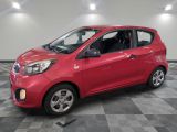 a red car is parked in a room with a checkered floor