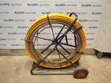 a yellow hose on a cart with a red wheel