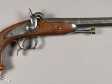 an old gun with a wooden handle on a white surface