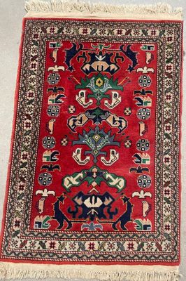 a red and blue rug with a design on it
