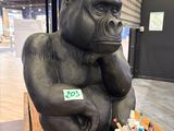 a statue of a gorilla sitting on a table with pens and pencils