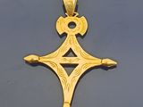 gros plan d'une croix en or sur une surface noire