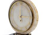 une horloge posée sur un socle en marbre
