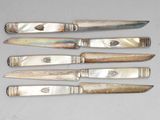 six knives are lined up in a row on a table