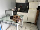 a small kitchen with a microwave, refrigerator, and a table