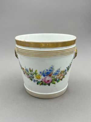 a close up of a vase with flowers on it on a table