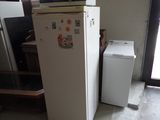 un réfrigérateur blanc orné d'aimants, à côté d'une machine à laver