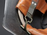 leather helmet with a leather strap and a metal buckle