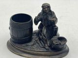 a figurine of a man sitting next to a barrel
