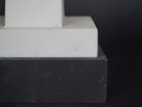 a statue of a man sitting on top of a white pedestal