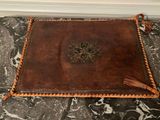 brown leather book with tassels on a marble floor