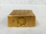 a small gold object sitting on a white surface