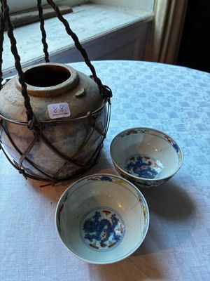 trois bols et un vase posés sur une table près d'une fenêtre