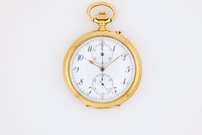 a close up of a gold pocket watch on a white surface